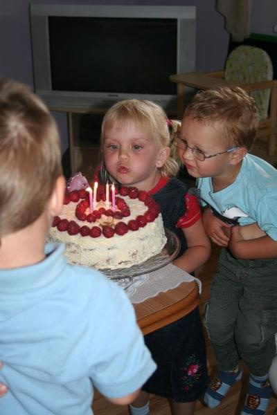 Dmuchanie świeczek na imprezie dla dzieci.